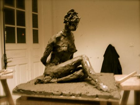 Femme aux jambes croisées au sol sculptée d'après ronde-bosse